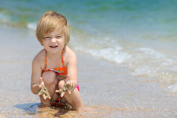 Wall Mural - Beautiful girl in swimsuit playing on the beach