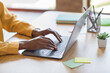 © deagreez - Cropped photo portrait of african american woman's hands typing on laptop in modern office indoors