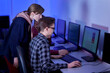 © Evgenia - A group of people working as programmers discuss their work sitting in the office. The work of a programmer. Blue light.