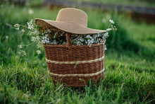Summer. A Basket Of Wildflowers On The Grass During The Day And Decorated With A Garden Hat.