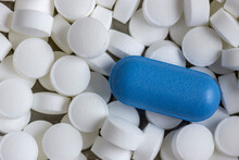 Blue Oblong Tablet On A Background Of White And Round Tablets Close-up.
