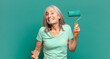 © kues1 - middle age grey hair woman with a paint roller decorating her wall
