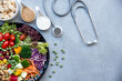 Health Care.  Fresh vegetable salad with medical stethoscope and equipment dumbbell for diet and weight loss for healthy care and protect virus,