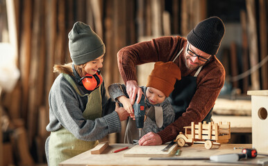 Happy family doing woodwork together in workshop