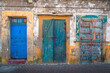Three colourful yet decayed doors on the streets of the historic old town of Essaouira, Morocco.