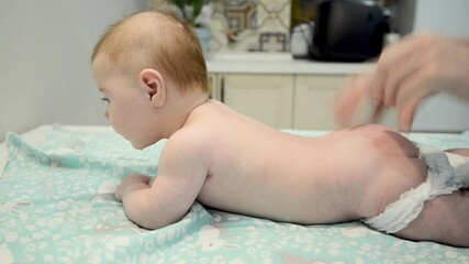 therapist giving a baby boy a back massage. relaxing newborn kid. baby massage concept