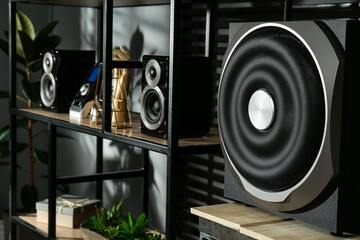 Modern powerful audio speaker system on shelving indoors