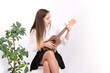 © Enrique Micaelo  - Young woman with guitar on white background with copy space