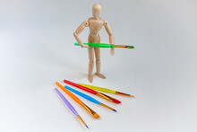 A Wooden Mannequin With A Lot Of Bright Colorful Brushes