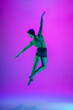 © master1305 - Power. Young and graceful ballet dancer on purple studio background in neon light. Art, motion, action, flexibility, inspiration concept. Flexible caucasian ballet dancer, moves in glow.