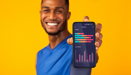 Aufkleber - Cheerful black man demonstrating application on smartphone screen with sport activity progress