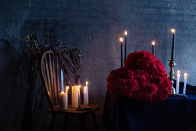 Burning White Candles On A Vintage Wooden Chair And Red Flower Heart On The Table With Candles