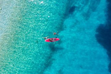 Wall Mural - kayaking. sup. aerial view of floating board and people on blue sea at sunny day. travel and active 