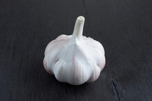 Unpeeled Ripe Garlic On A Dark Wooden Background