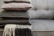 © Gillian Vann/Stocksy - grey sofa with cushions and blankets pile up