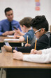 © Sean Locke Photography/Stocksy - Classroom: Student Uses Cell Phone While Doing Schoolwork
