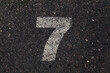 © MyMicrostock/Stocksy - Number 7 Printed on White Over Dirty Asphalt