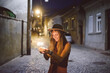 © Brkati Krokodil/Stocksy - Beautiful young woman standing on the street with sparklers
