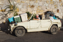 Senior Man Using Overloaded Old Safari Car As Moving Truck