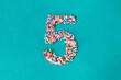 © Kathryn Swayze/Stocksy - The number five built from nonpareils