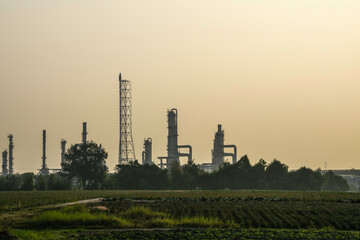 Shadow of industrail factory plant with green fields in the morning