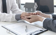 © Puwasit Inyavileart - Real estate agent or sales manager has offered home sales and explained the terms of signing the house purchase contract and free home insurance, Finance and after-sales service concept.