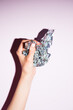 © Katarina Radovic/Stocksy - Female Hand Holding Shiny Silver Paper