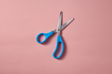 light blue scissors on pink background