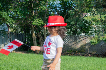 Kid citizen celebrating Canada Day holiday on first day of July. Canadian flag