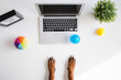 © Leandro Crespi Studio/Stocksy - A dog is working on a white desk with computer, plant, motivational quote and toys - dog hands