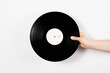 © Pixel Stories/Stocksy - Hand holding vinyl record over white background