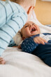 © Beatrix Boros/Stocksy - Baby laughing with his older brother