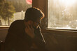 © Leandro Crespi Studio/Stocksy - Portrait of a sad pensive reflective bearded man indoors with backlight on sunset