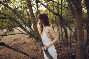 romantic woman in nature near trees in the forest