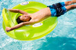 © Curtis Kim/Stocksy - Young boy smiling and laying down on inner tube