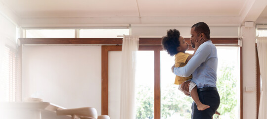 Wall Mural - Loving African-American father hugging kissing his cute baby son.