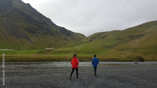 People Walking On Road Against Mountains