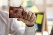 © kamiphotos - Men holding red credit cards, credit cards can be used to pay for goods and services in general or online stores, credit card concept.