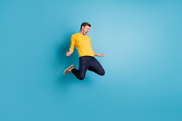 Full length body size view of nice cool crazy cheerful guy jumping having fun celebrating isolated over bright blue color background