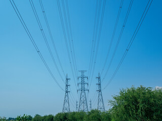 high voltage transmission towers with power line over blue sky background the electricity infrastructure from power plant to industrial and household