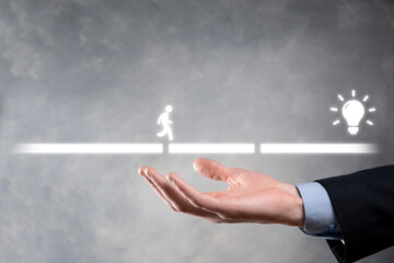 Male business man hand hold a connecting block between two sets of bridge road for a silhouetted man to walk idea icon.