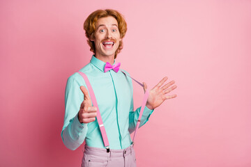 Sticker - Photo of young happy positive smiling funky funny man pull suspenders point finger at camera isolated on pink color background