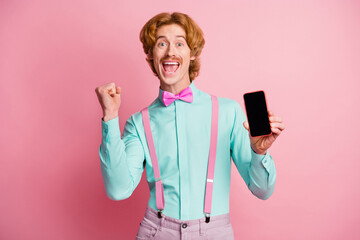 Wall Mural - Photo of young happy joyful excited crazy cheerful positive happy man win smartphone isolated on pink color background