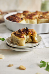 Sticker - Vertical shot of delicious pesto pizza roll with pine nuts and basil on a white table