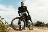 Fototapeta  - Downhill rider fully equipped with protective gear and his bicycle