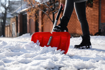 Wall Mural - Person shoveling snow outdoors on winter day, closeup