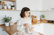 Cute young girl holding glass jar with heart shaped cookies.