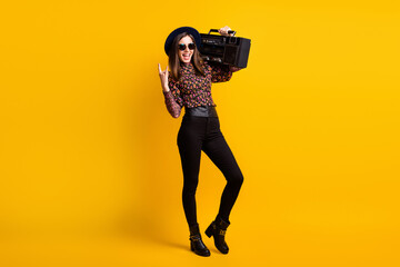 Wall Mural - Full length body size photo of happy brunette keeping cassette recorder showing heavy metal sign isolated vivid yellow color background