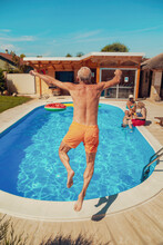 Elderly Man Jumping Into Swimming Pool