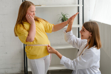 Nutritionist and fat girl celebrating first good results of a diet